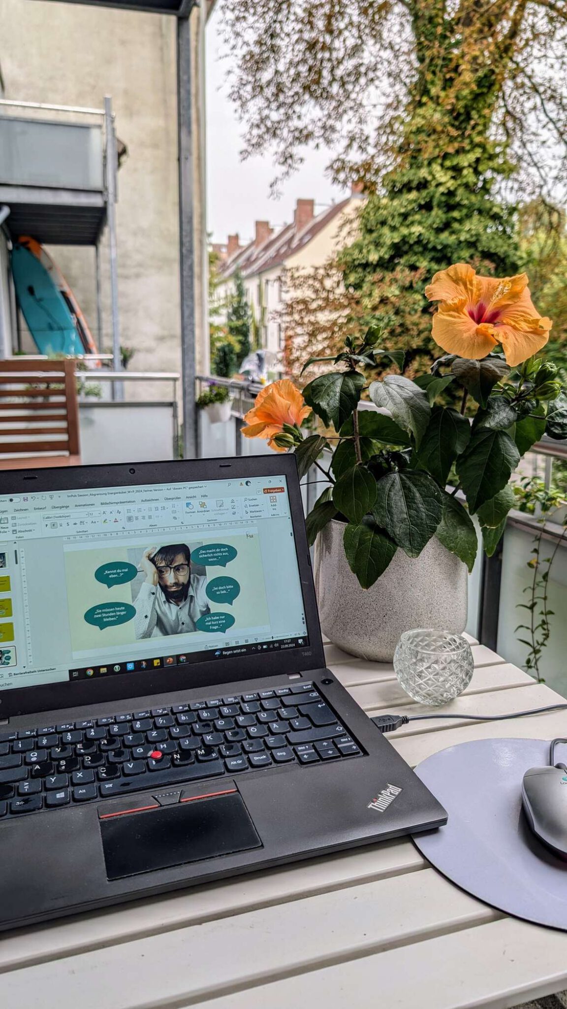 Laptop auf einem Tisch neben Blumen in einem Gartenumfeld, passend fuer Online-Coaching und Entspannungstraining.